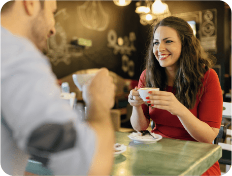A man and woman are drinking their tea in a restaurant